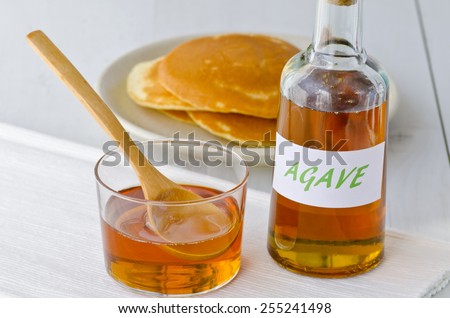 Agave syrup and pancakes.. Alternative sweetener to sugar. Selective focus. White background. Taken in daylight.