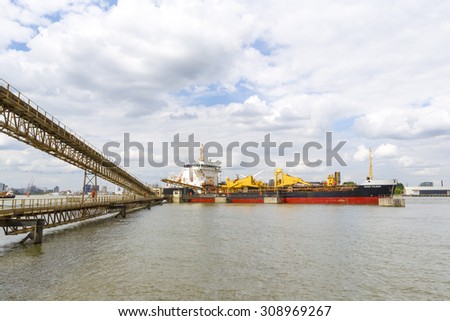 LONDON - August 15 : The cargo ship Sand Fulmer offloading its cargo of aggregate while docked in the River Thames.  August 15th 2015