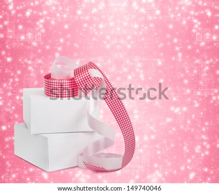 White boxes with gifts with pink ribbons on the beautiful abstract background