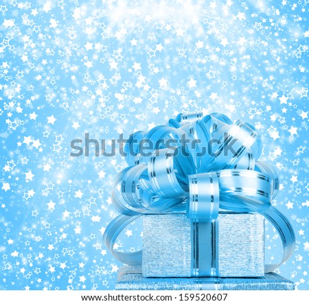 Gift box in blue wrapping paper on a beautiful abstract background