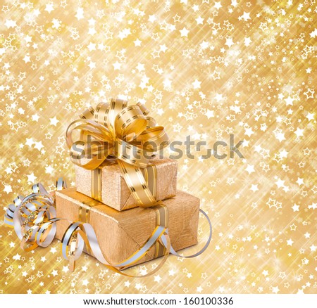 Gift box in gold wrapping paper on a beautiful abstract background
