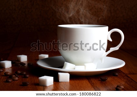 Fresh cup of hot coffee with sugar and natural grains on a wooden table