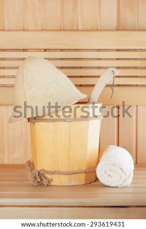 Traditional wooden sauna for relaxation with bucket of water and set of clean towels