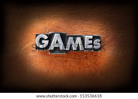 The word games made from vintage lead letterpress type on a leather background.