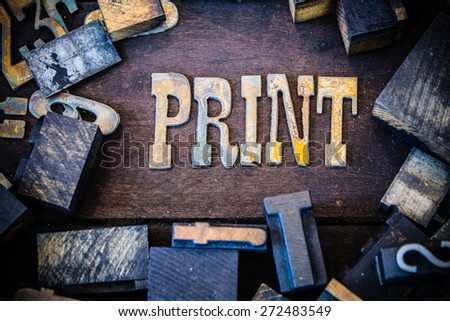 The word PRINT written in rusted metal letters surrounded by vintage wooden and metal letterpress type.