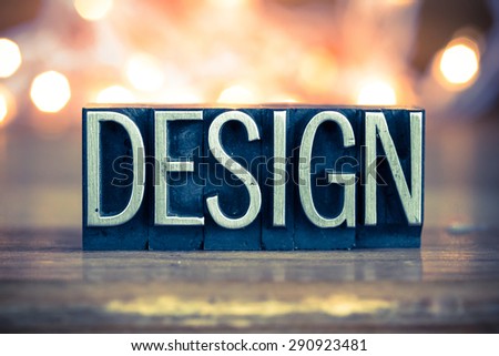 The word DESIGN written in vintage metal letterpress type on a soft backlit background.