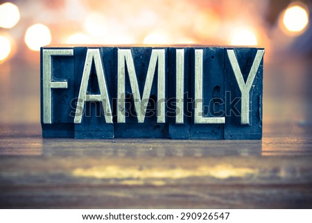 The word FAMILY written in vintage metal letterpress type on a soft backlit background.