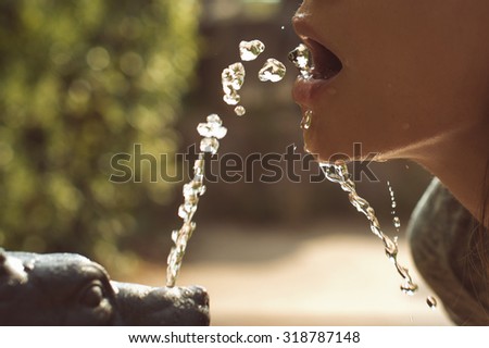 woman lips, drinking water from small fountain