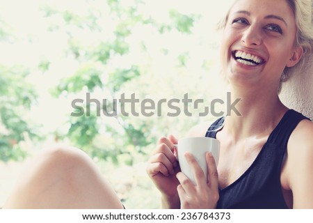 Pretty woman enjoying her morning coffee on a veranda