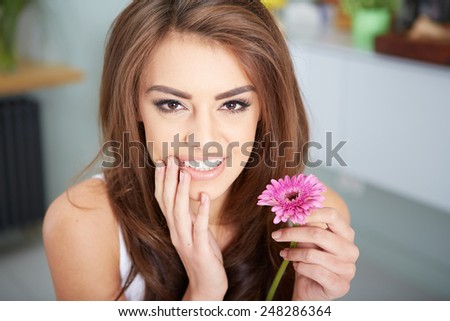 beautiful young brunette woman with a flower