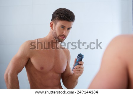 Close up portrait of young handsome man with perfect skin and hair. Shaving by electric shaver