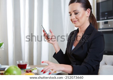 A telephoning woman with tea in kitchen