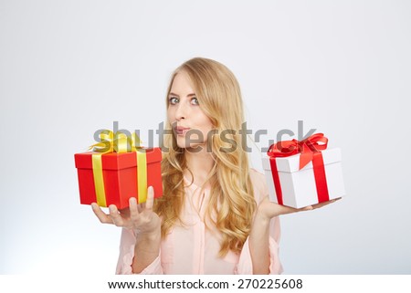 Beauty with gift box. Beautiful young blond hair woman holding gift box and smiling while standing isolated on white background