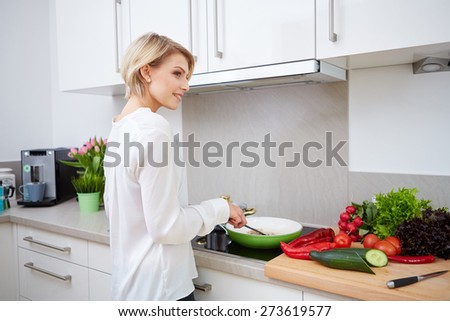 Blonde woman using a tablet computer to cook in her kitchen