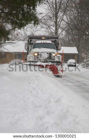 Snow plow removing snow from street.