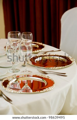 wedding table with white tablecloth and silver platters set for dinner