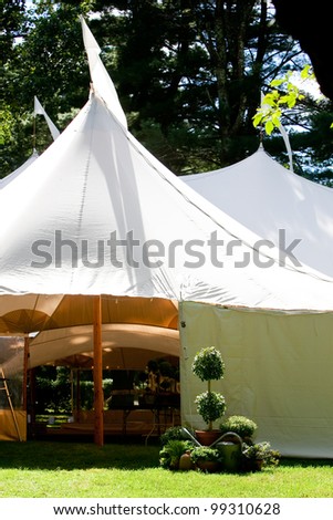 a large white wedding tent set up outside for a catered event