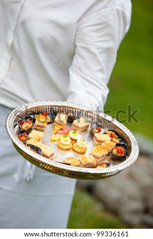 a waiter serving appetizers at a wedding or catered event