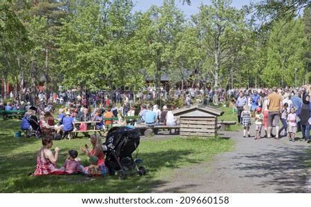 UMEA, SWEDEN ON JUNE 06. People celebrating the Swedish National Day on June 06, 2014 in Umea, Sweden. Unidentified people in park next to Gamlia Homestead.