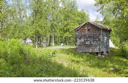 Wooden tepee, warehouse building in the Nordic taiga mountains. Elderly wooden buildings in a landmark, memorial in the Nordic mountain and countryside. Summertime in the area.