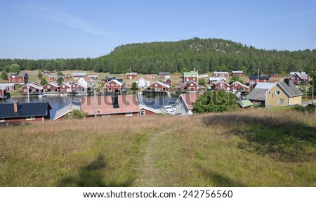 BALTIC SEA, SWEDEN ON JULY 22. View of a small village, harbor in sunshine on July 22, 2014 in Trysunda, Sweden. Small marina and red buildings in bright sunshine. Lawn, grass this side.