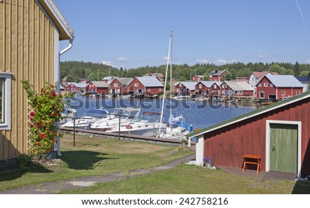 BALTIC SEA, SWEDEN ON JULY 22. View of a small summer harbor in sunshine on July 22, 2014 in Trysunda, Sweden. Very small marina, buildings in bright sunshine. Garden this side.