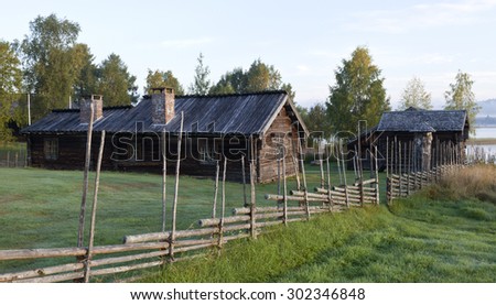 SARNA, SWEDEN ON SEPTEMBER 07. View of an old wooden homestead by a lake on September 07, 2013 in Sarna, Sweden. Typical in rural part of Sweden. Wooden fence this side.