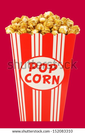 caramel popcorn in a decorative paper popcorn cup isolated on a red background