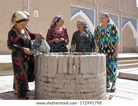 KHIVA, UZBEKISTAN - MAY 20: Five old women in traditional clothes standing around a well on May 20, 2012 in Khiva, Uzbekistan. The well is the oldest part of Khiva.