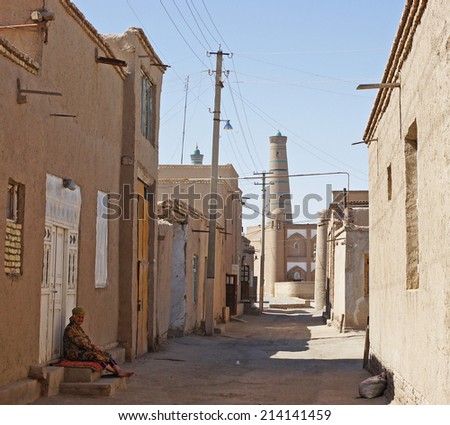 KHIVA, UZBEKISTAN - MAY 20, 2012: Old woman sitting in the shadow on a hot day in Khiva on May 20, 2012 in Uzbekistan, Asia.