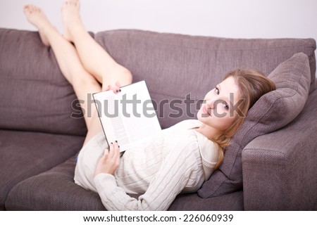 beautiful girl reading a book on sofa