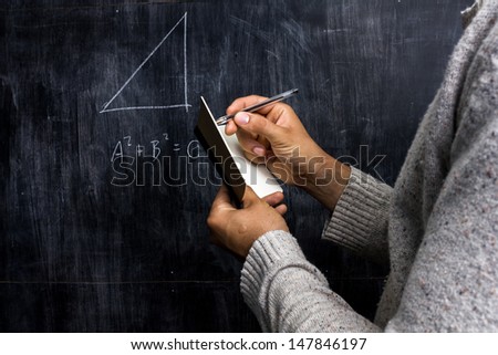 Man taking notes of math theorem on blackboard