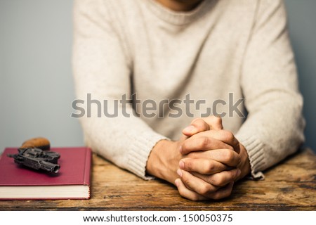 Praying man with a gun and important book