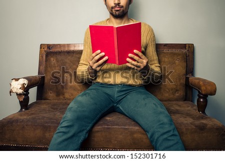 Young man reading on old sofa