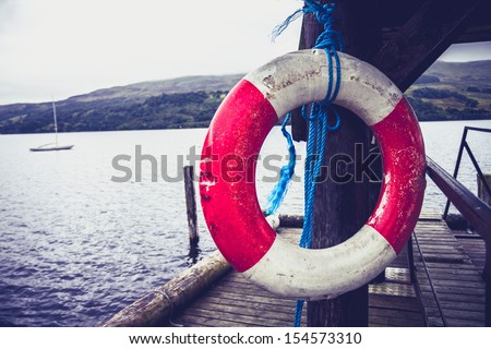 Life buoy hanging on pier at lake