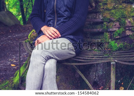woman sitting on bench in forest