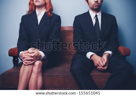 Businessman and woman waiting on sofa in lobby