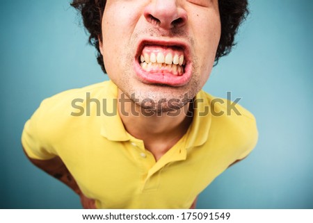Young man is grinding his teeth and looking angry