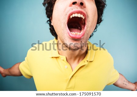 Young man is screaming with his mouth wide open