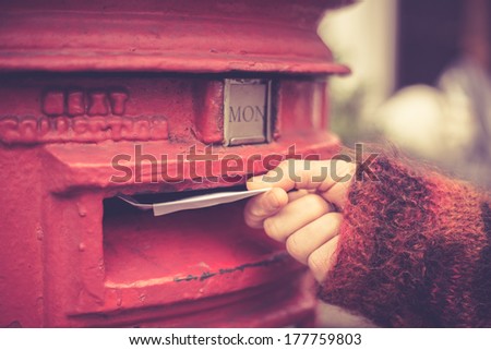 Closeup on a woman\'s hand as she is posting a letter