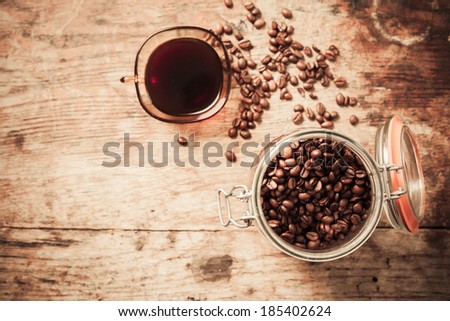 Overview shot of cup of coffee and beans on a wooden table