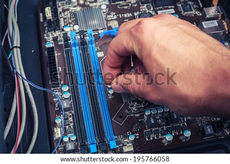 A hand is fixing computer components