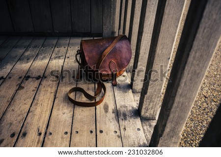 A woman's leather bag on a wooden terrace