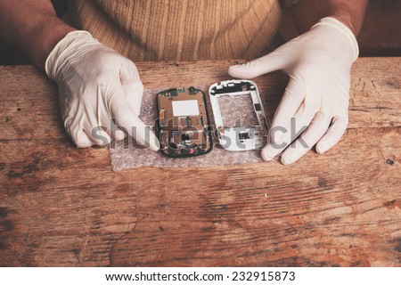 A technician is fixing and replacing the broken screen on a smart phone