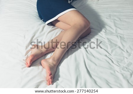 The legs of an elegant young woman lying on a bed