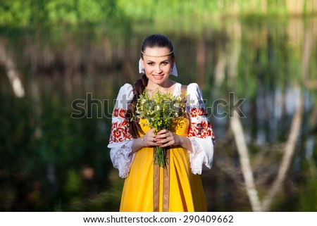 Beautiful girl in russian national clothes outdoors