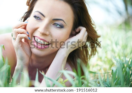 Beautiful laughing young woman in the park on a warm summer day