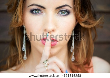 Portrait of beautiful woman with finger on lips