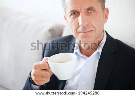 Mid age man drinking coffee at home