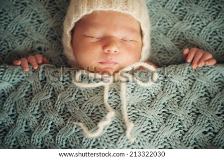 Newborn Baby in Wrap and Red Blanket - close portrait
